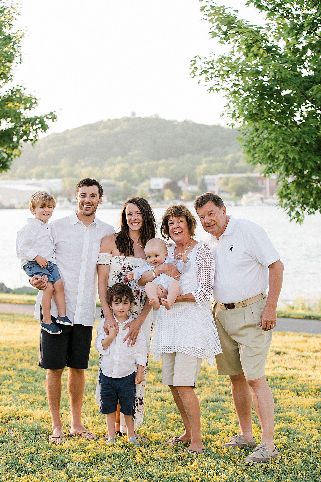 Family portrait with kids, parents, and grandparents by the lake