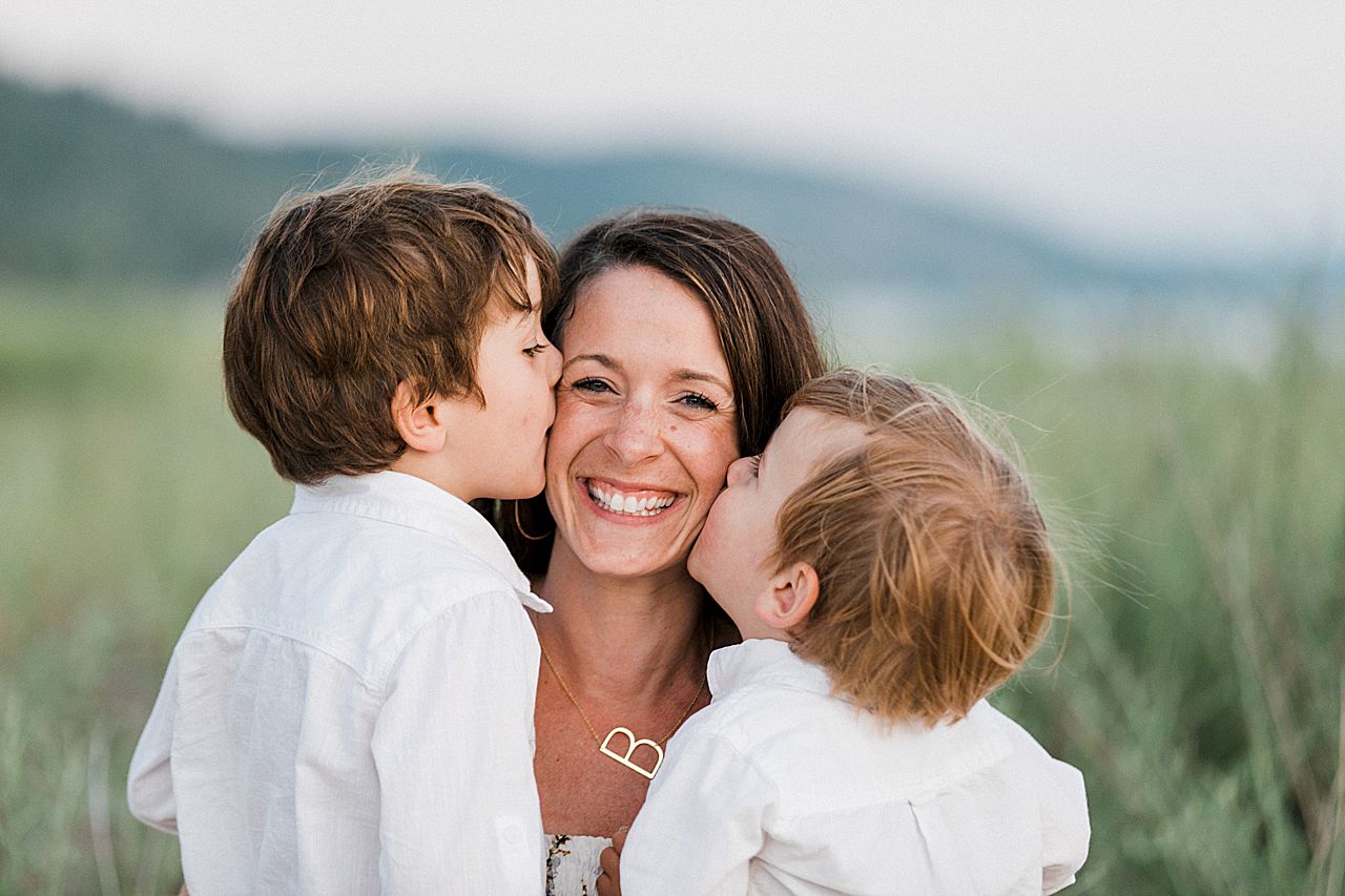 Two brothers kissing their mom's cheek