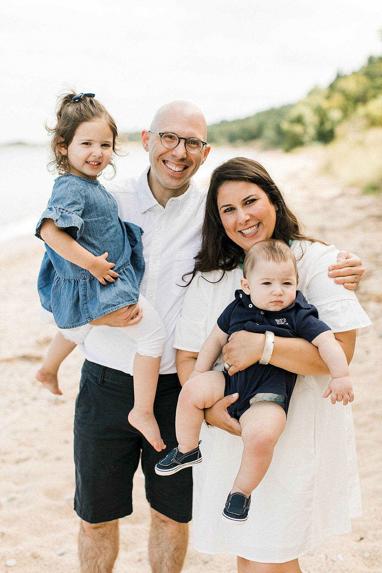 Family of four posing for a photo on the beach