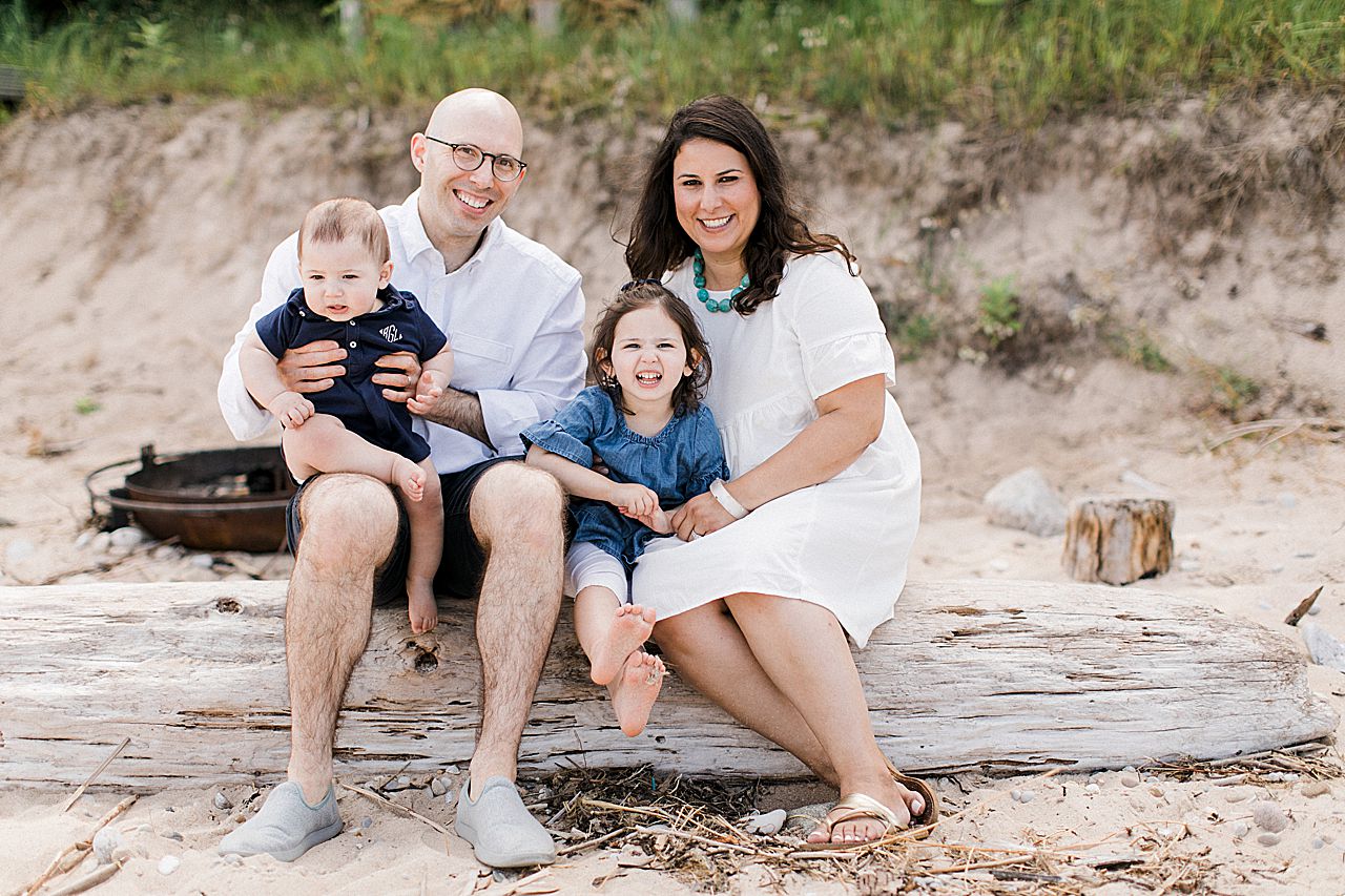 Young family posing on a log at Lake Charlevoix, Michigan