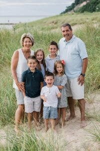 Grandparents with all their grandkids on a beach in Frankfort, Michigan