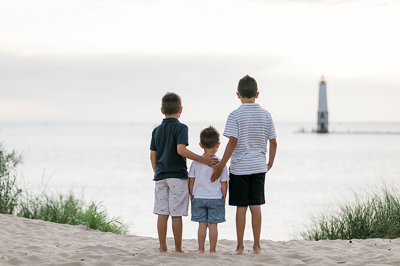 Three brothers standing together and watching the sunset