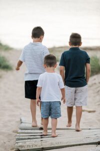 Three young boys walking down to the beach near Lake Michigan