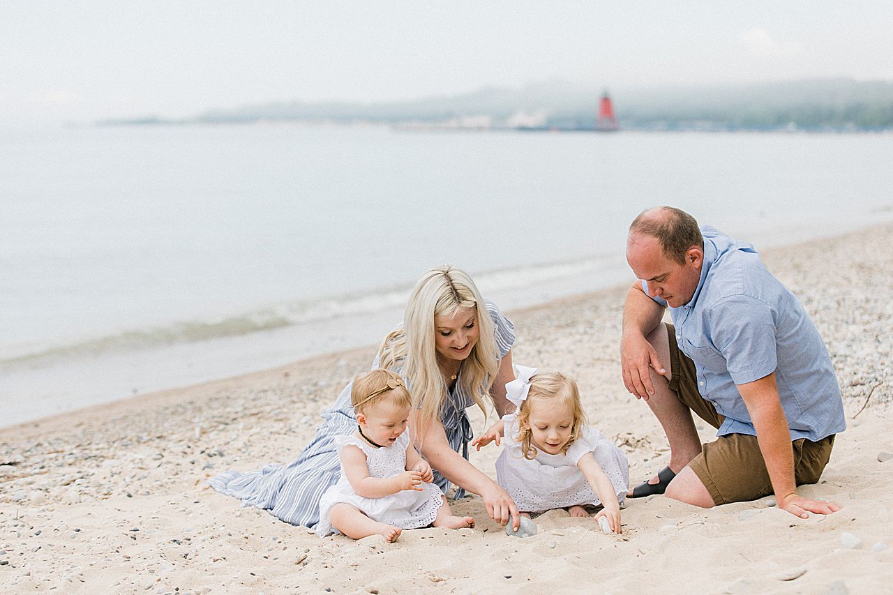 Parents playing in the sand with their daughters on a beach in Charlevoix, Michigan