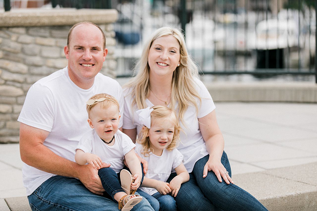 Parents sitting with their daughters near a marina
