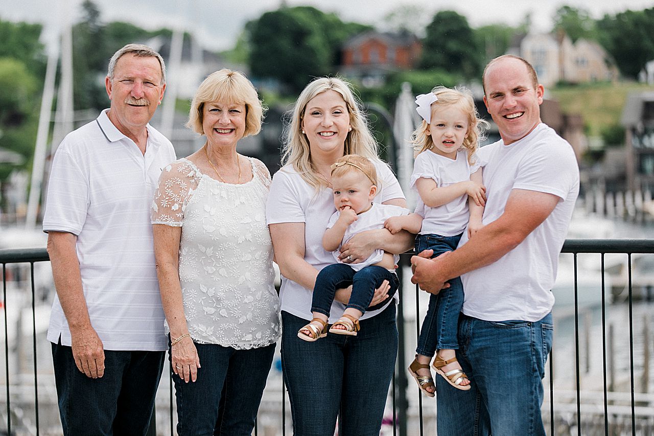 Close up of a family smiling in front of a marina in Northern Michigan