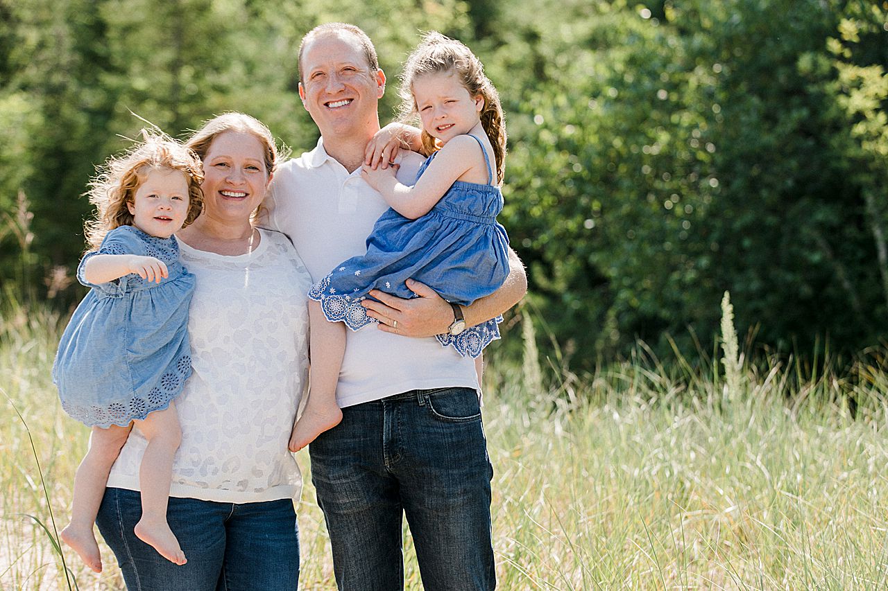 Mother and father holding their two daughters in Petoskey, Michigan