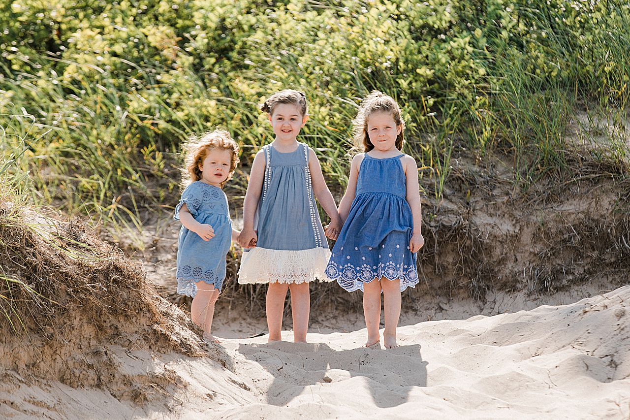 Cousins holding hands in the sand in Michigan