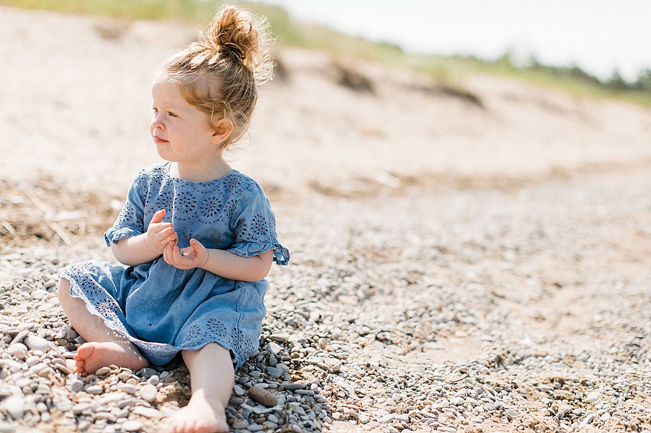 Young girl sitting in the sand on a beach