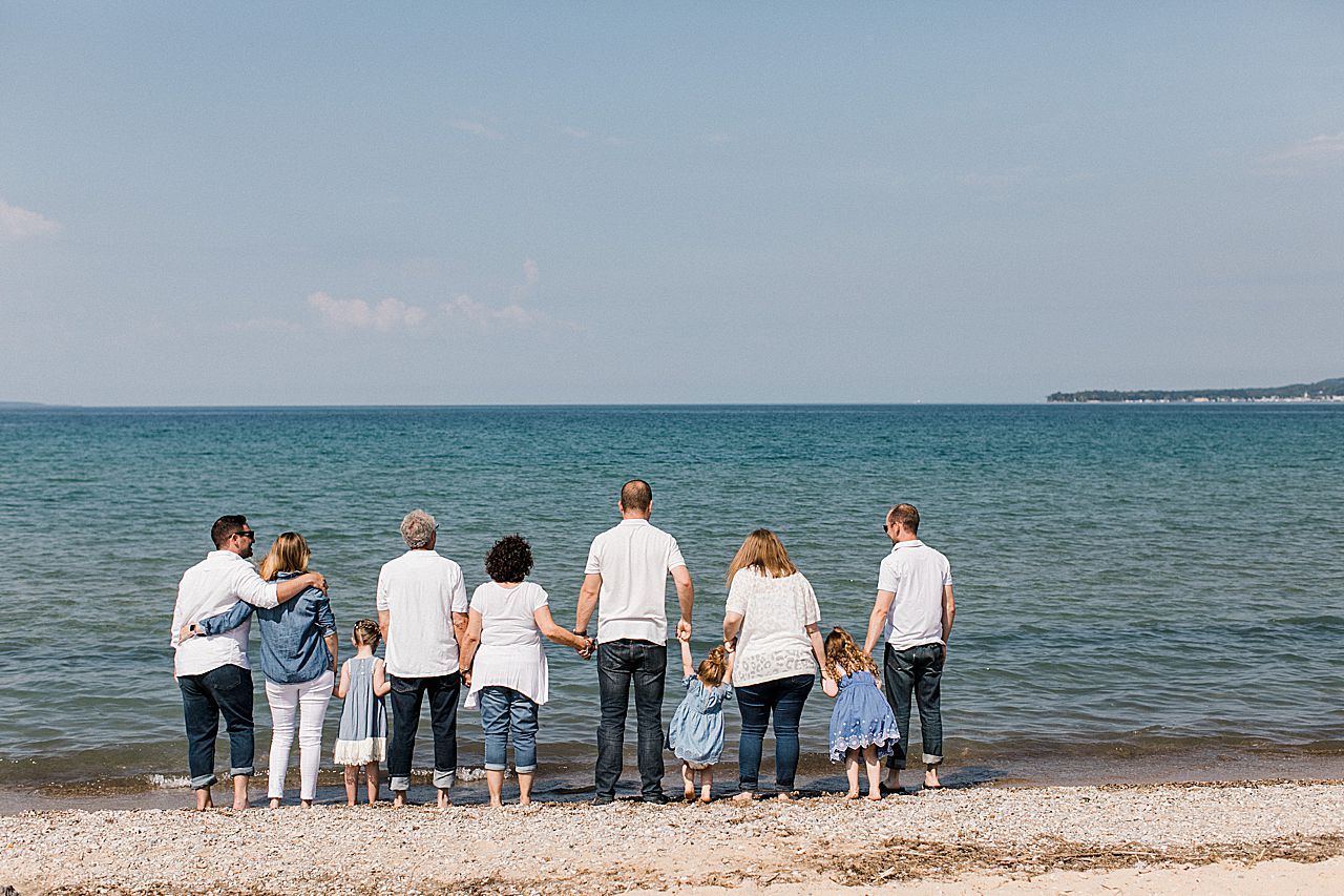Family holding hands and looking out a Lake Michigan