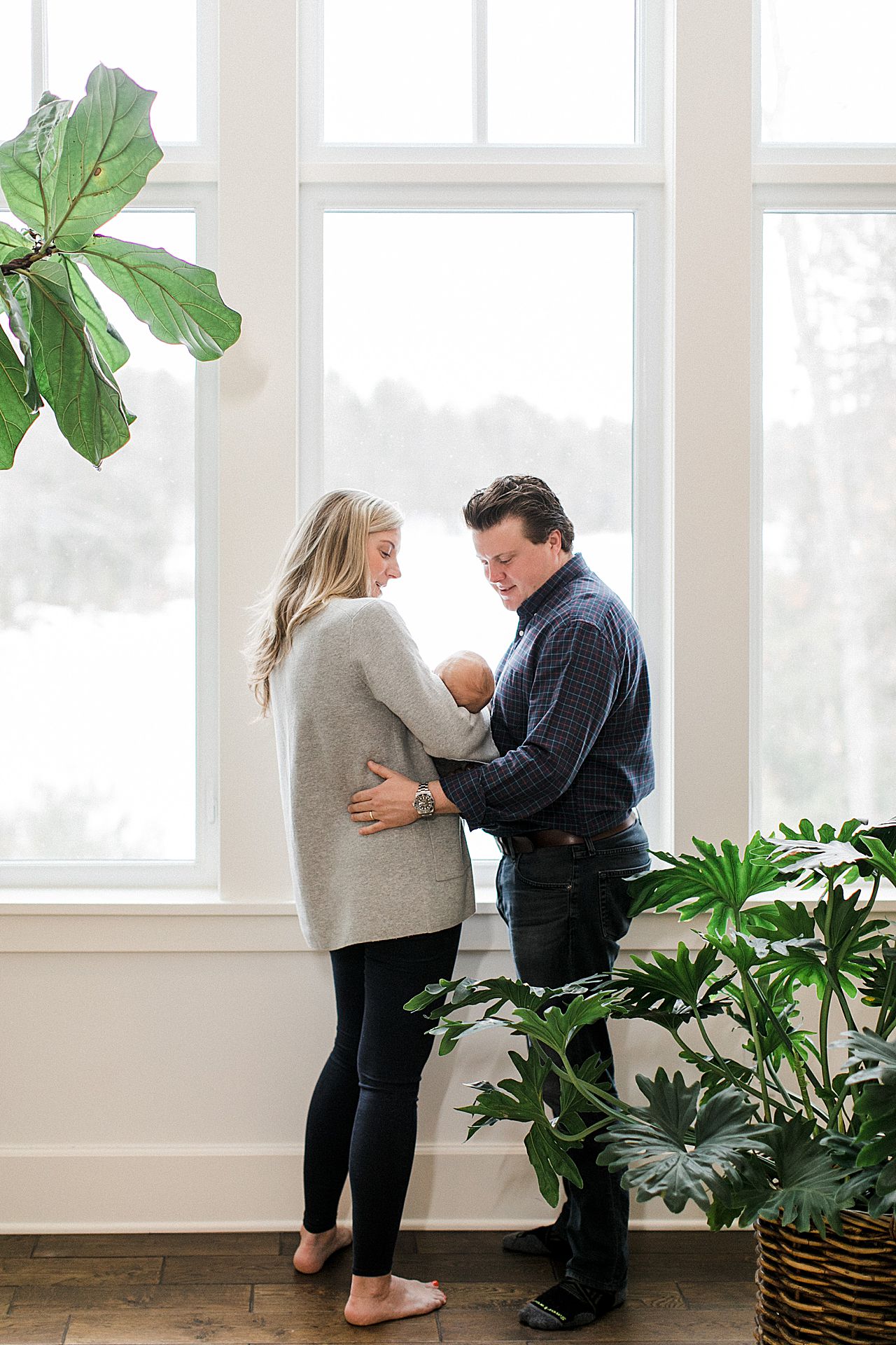 New parents looking at their baby in their home