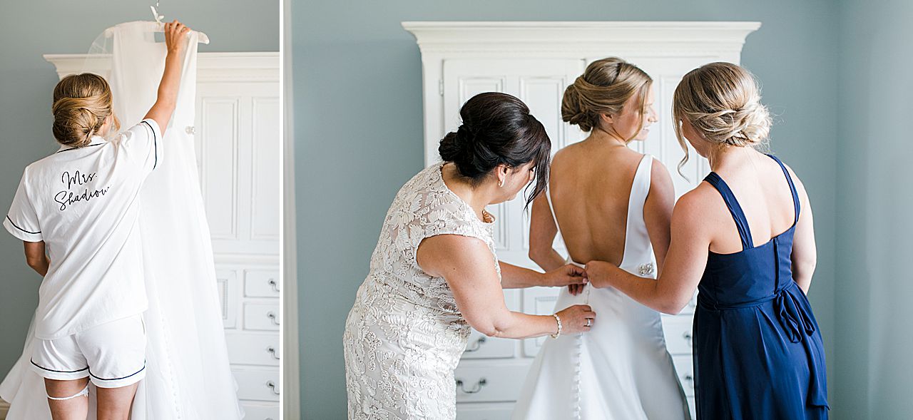 A bride reaching for her wedding dress on an armoire dresser and getting dressed with the help of her mother and sister