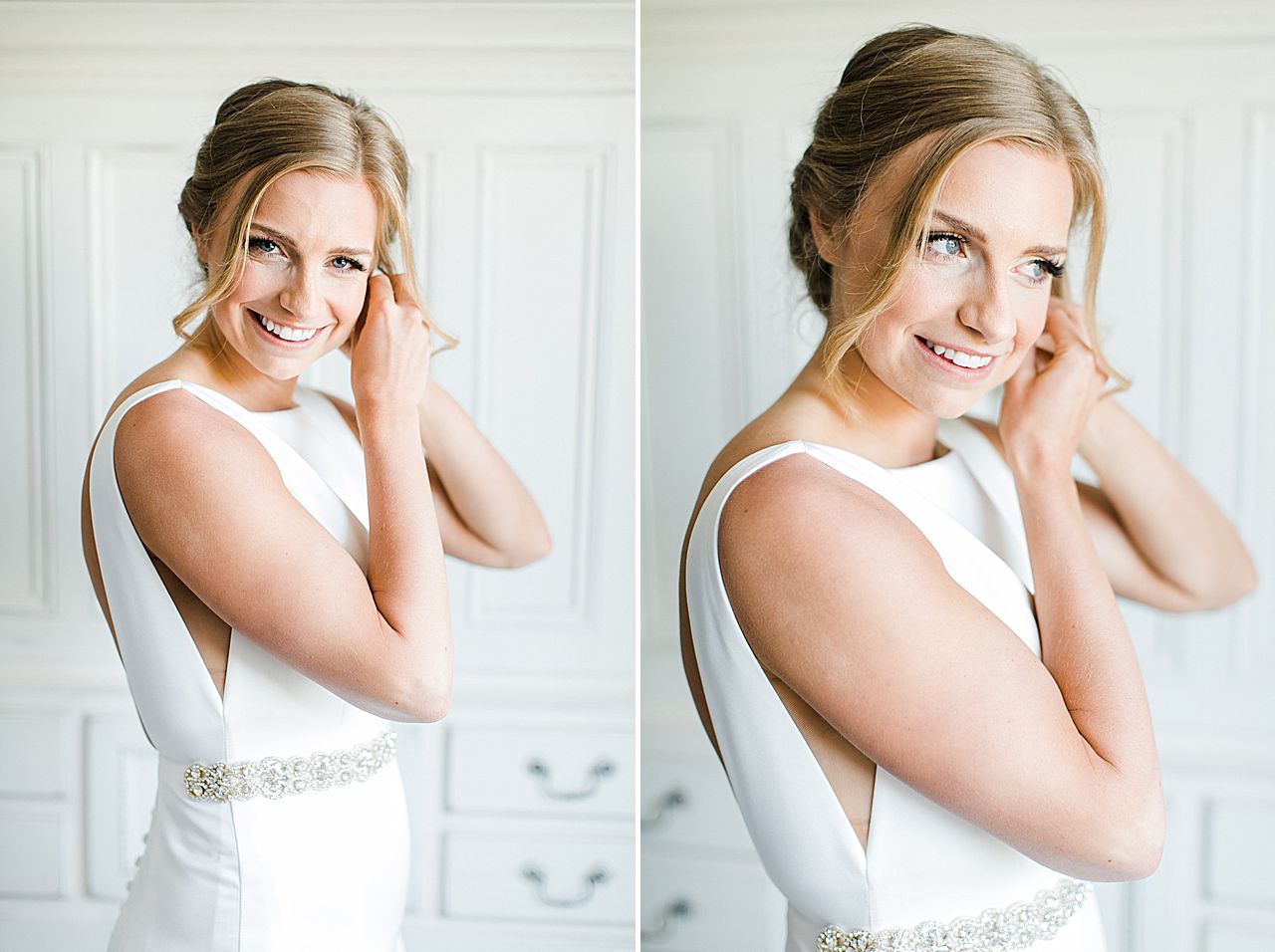 A bride in her wedding dress putting on her long crystal earrings