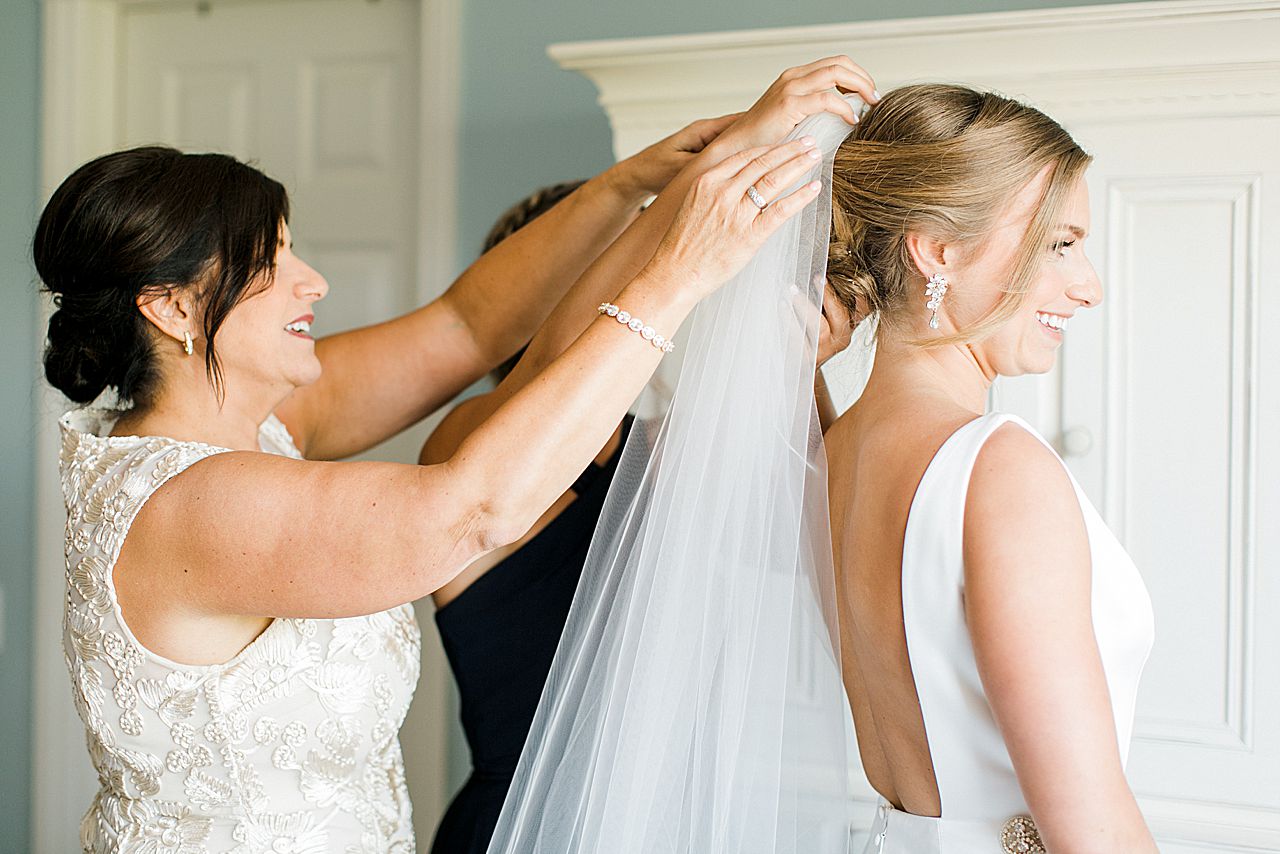 Brides mother and sister putting the veil into her hair