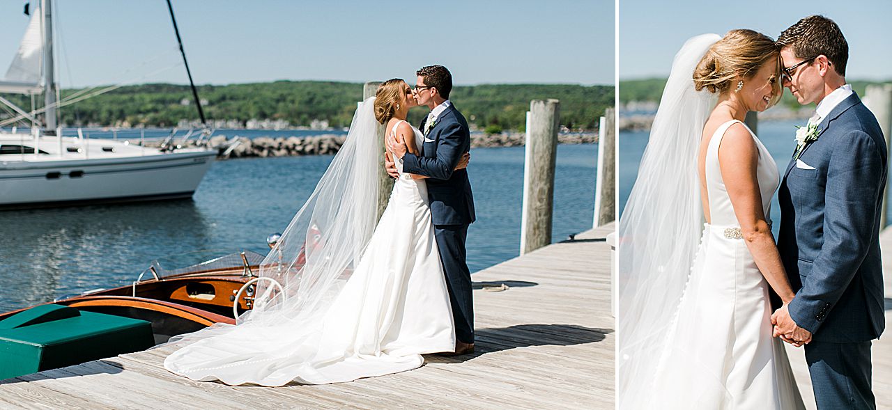Bride and groom kissing on a dock at The Harborage Marina in Boyne City, Michigan with a sailboat in the background