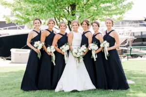 A bride and bridesmaids smiling with their white bouquets in Boyne City, Michigan