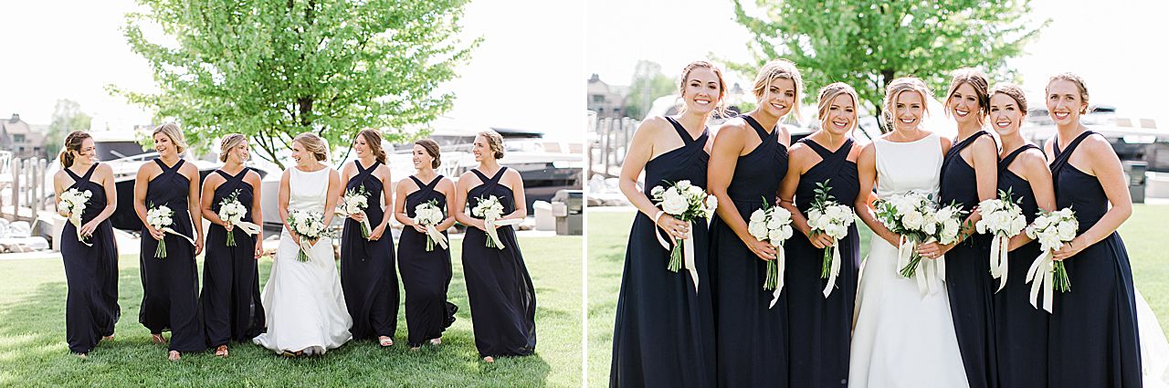 A bride and bridesmaids in navy blue dresses walking and laughing at each other in Nothern Michigan