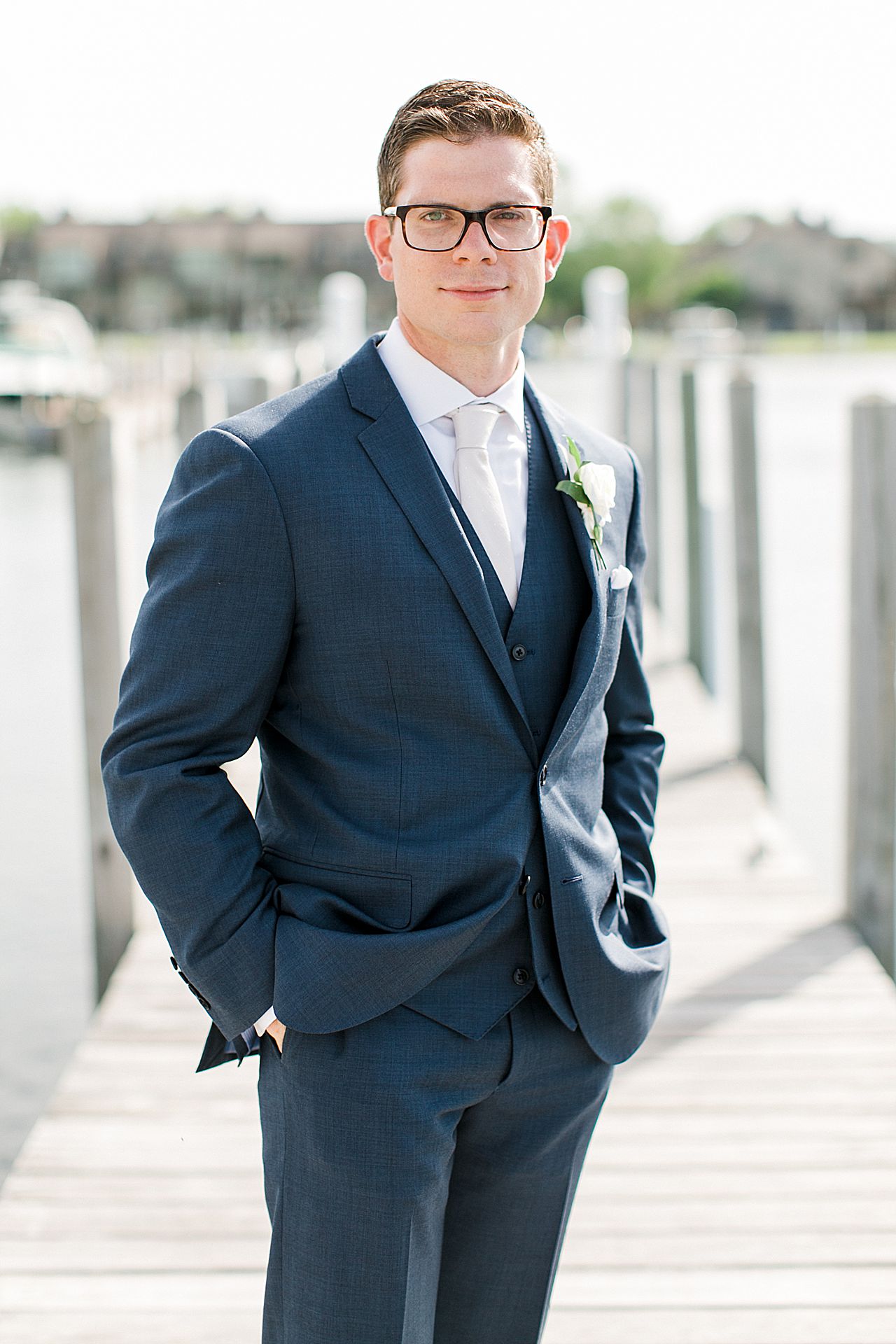 Portrait of a groom in a navy blue suit with his hands in his pockets in Northern Michigan