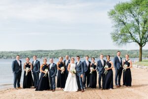 Classic wedding party portrait in navy blue attire at the beach along Lake Charlevoix in Boyne City, Michigan