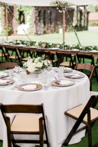 Circular table with wooden chairs, gold chargers, and white floral centerpieces at Boyne Mountain Resort in Boyne Falls, Michigan