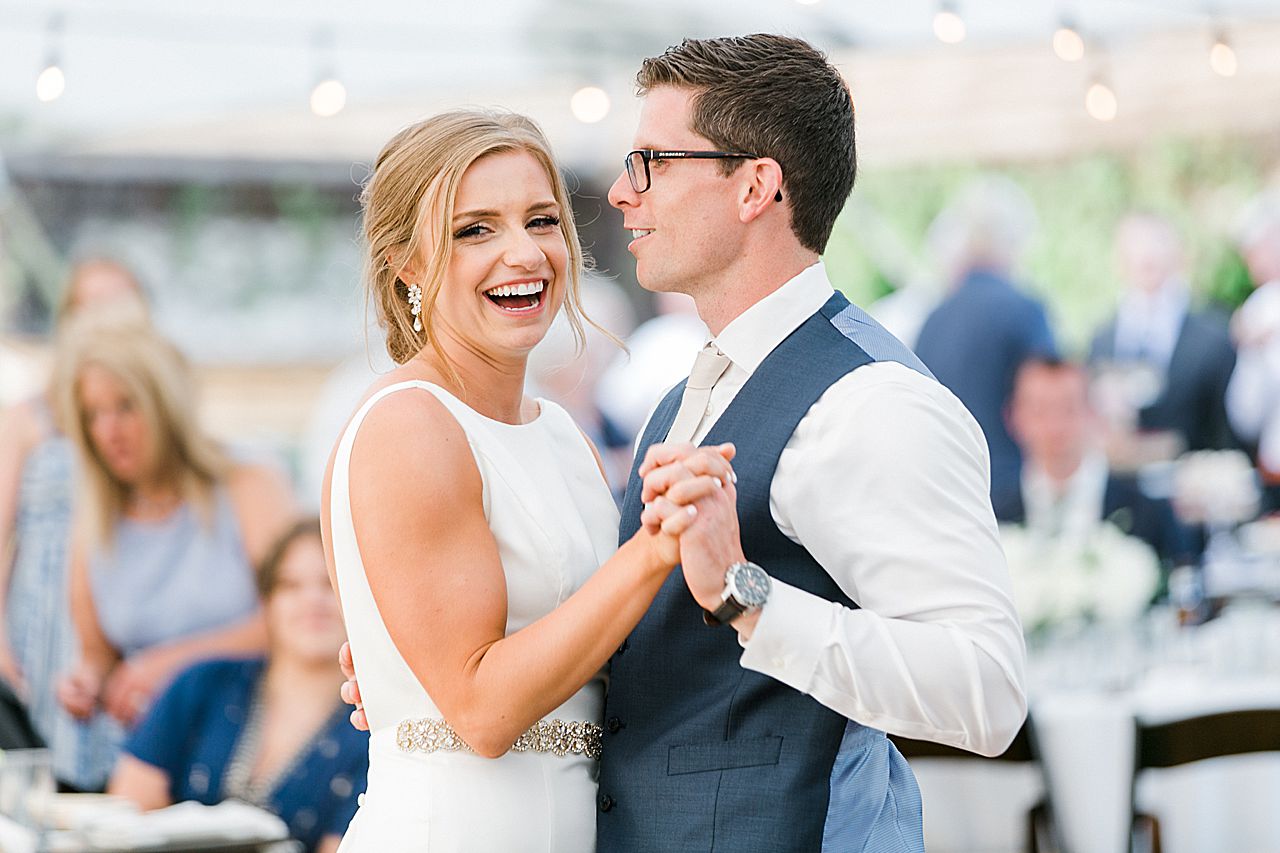 Bride laughing during the first dance under a white reception tent at Boyne Mountain Resort on Deer Lake