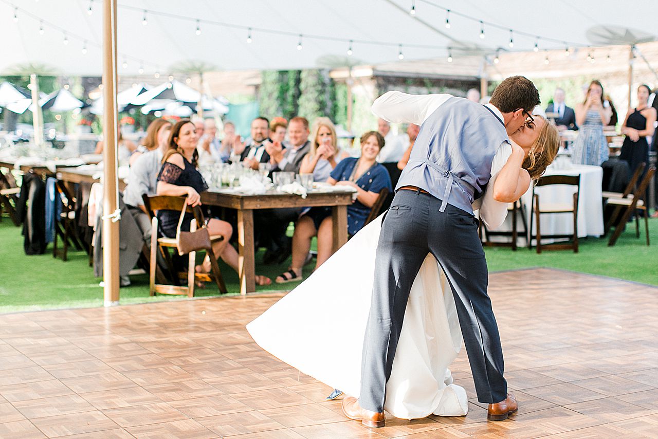 Groom kissing the bride during their first dance on Deer Lake in Boyne Falls, Michigan