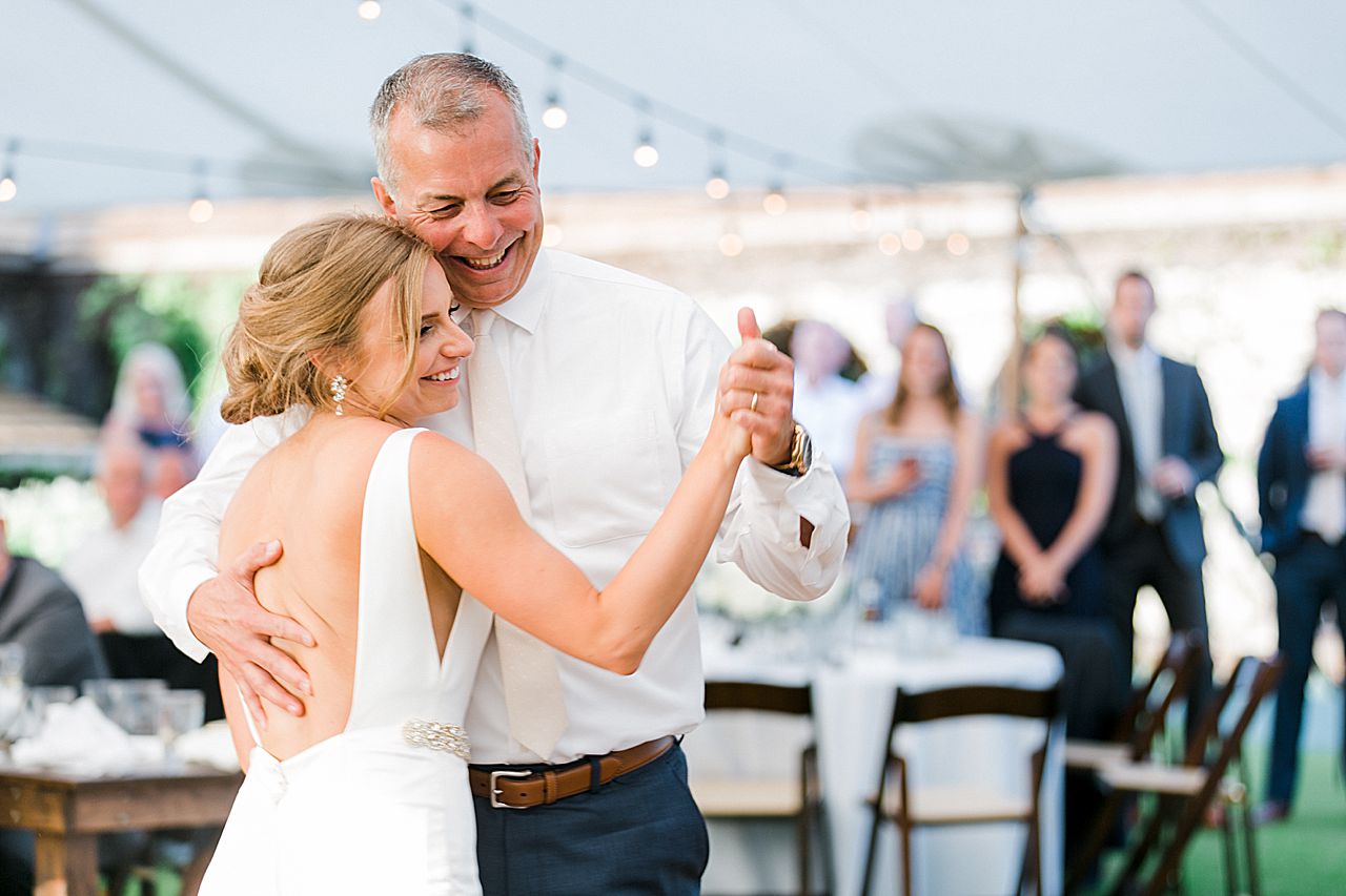 Bride and father of the bride laughing while dancing at a wedding reception on Deer Lake at Boyne Mountain Resort