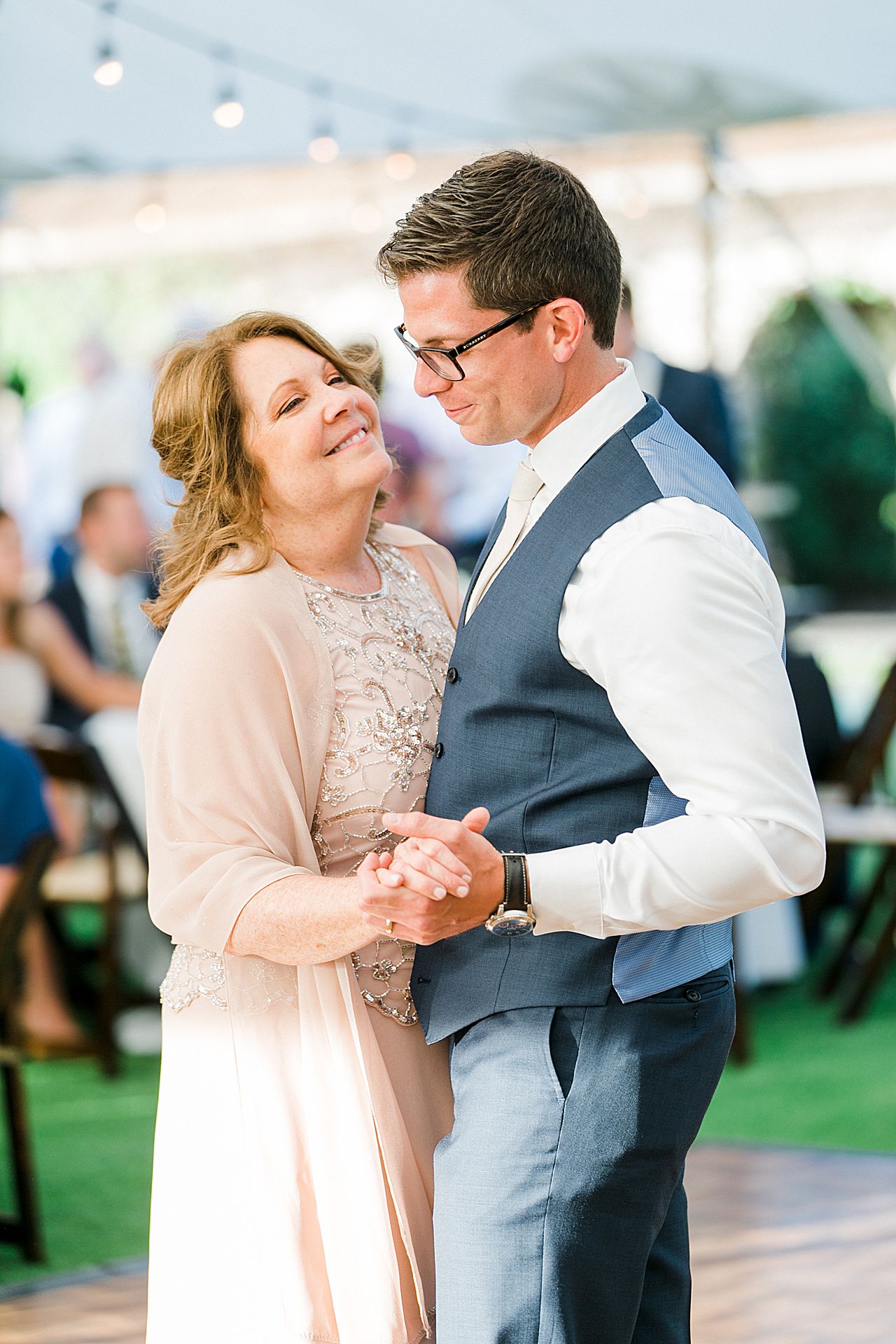 Mother of the groom looking up and smiling at the groom while dancing at a wedding reception in Northern Michigan