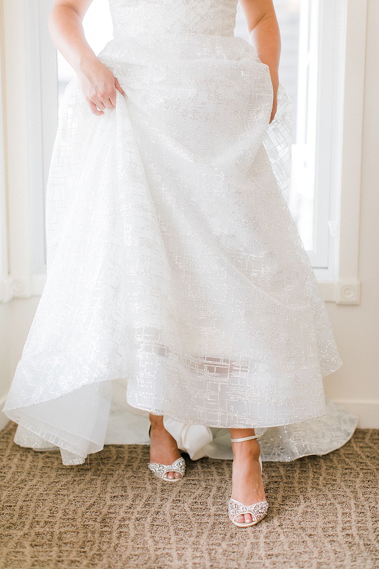 A bride slipping on her white wedding shoes