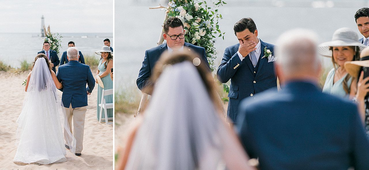 A groom wiping away a tear as his bride walks down the ceremony aisle towards him with Lake Michigan in the background