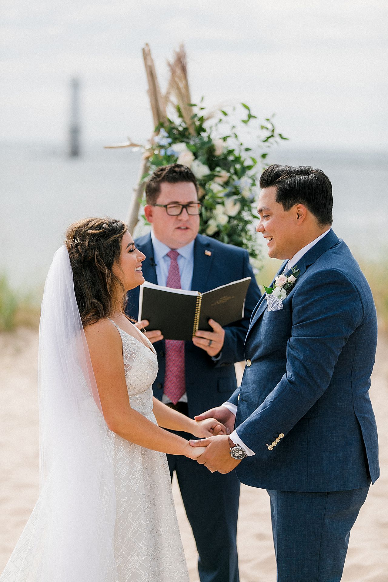 A bride and groom at their wedding ceremony by Lake Michigan at Harbor Lights Resort in Frankfort, Michigan