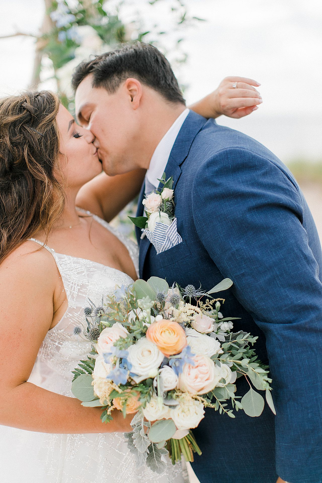 A bride and groom kissing on the beach in Frankfort, Michigan