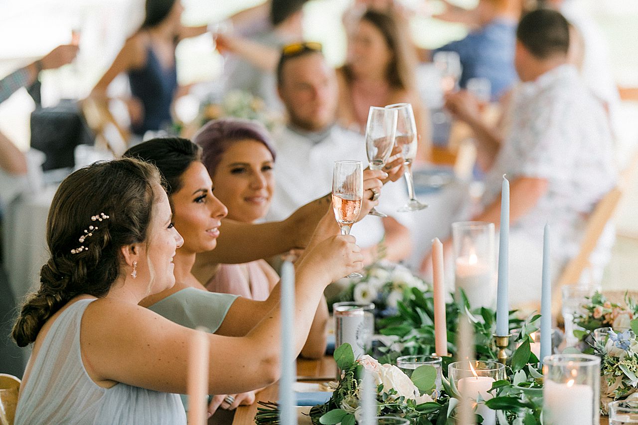 A bridesmaids clinking there champagne glasses at a wedding reception in Elberta, Michigan