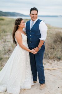 A bride and groom laughing on the beach at sunset in Northern Michigan