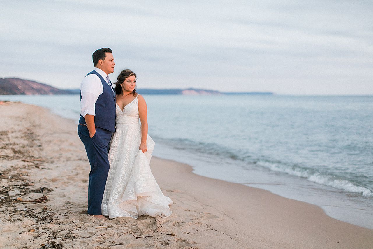 A bride and groom looking out at Lake Michigan at sunset in Elberta, Michigan