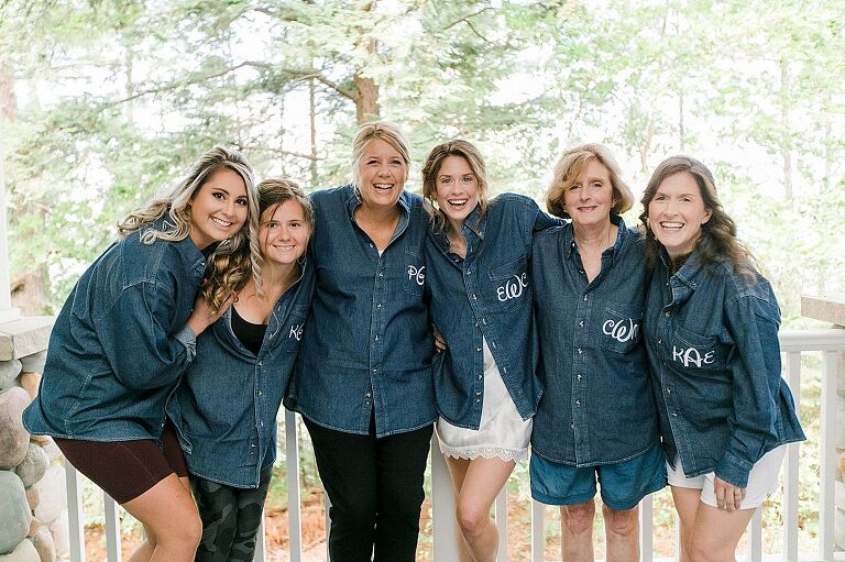 A bride and her closest friends wearing matching jean shirts with their monograms