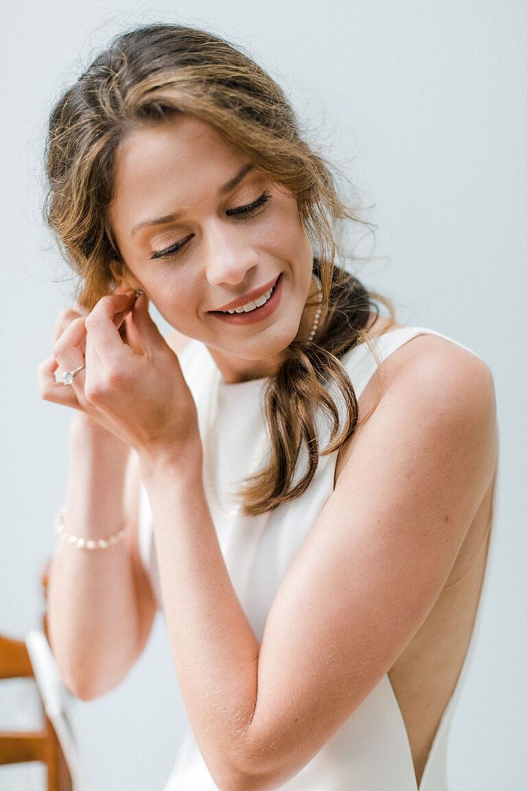 A bride putting on her earrings