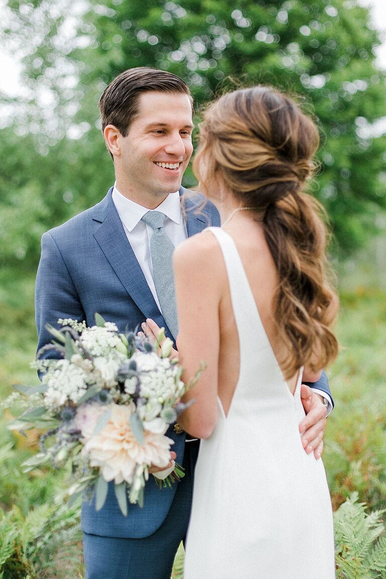 A groom smiling at his bride in Leland, Michigan