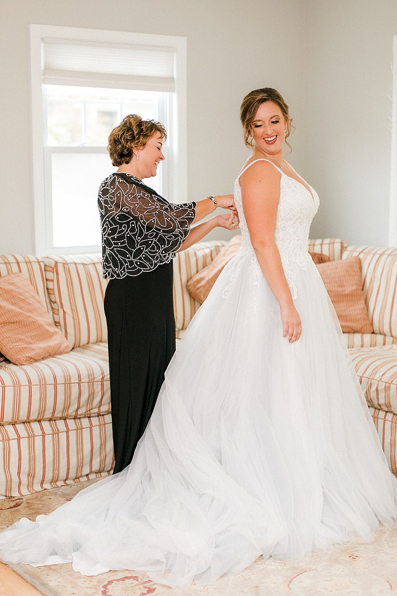 A bride getting into her dress with the help of her mother