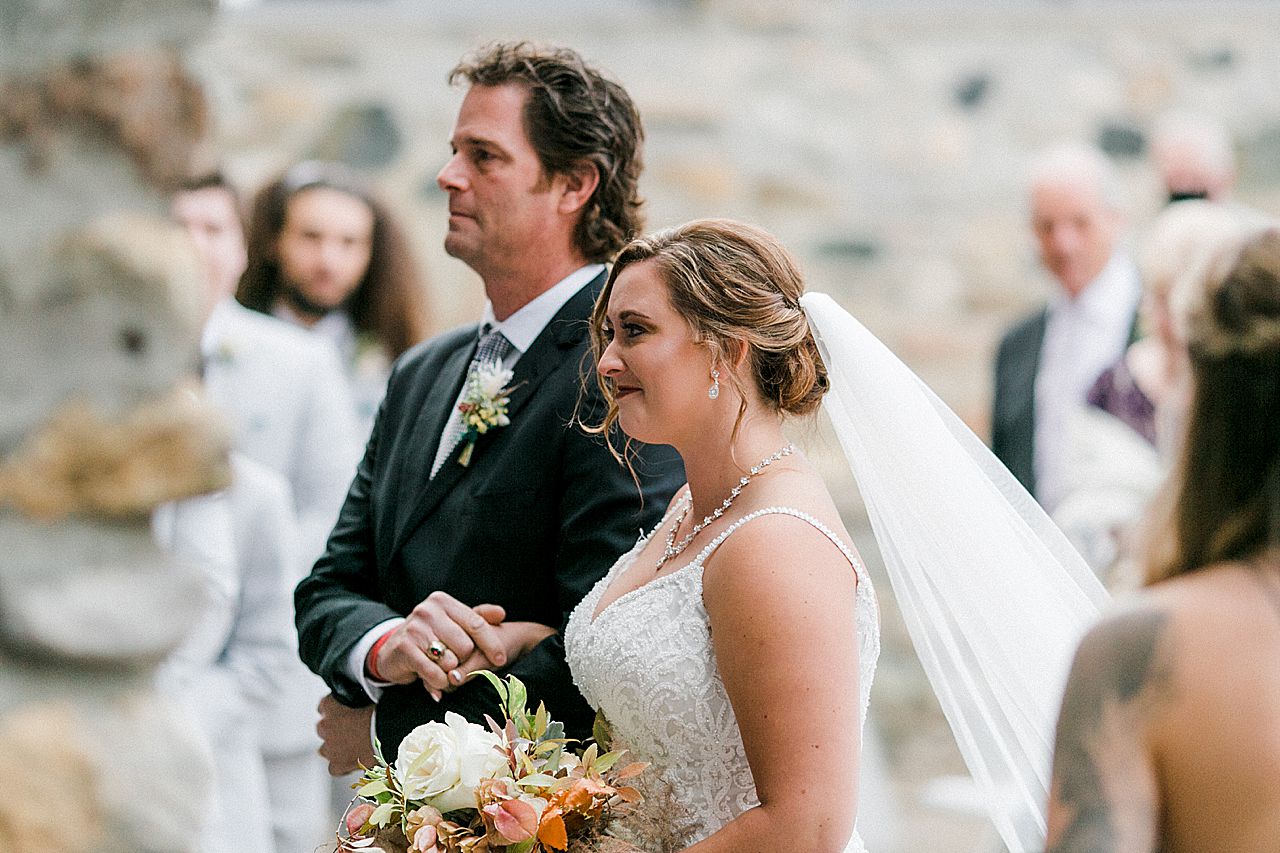 The bride standing with her father at the wedding ceremony in Charlevoix, Michigan