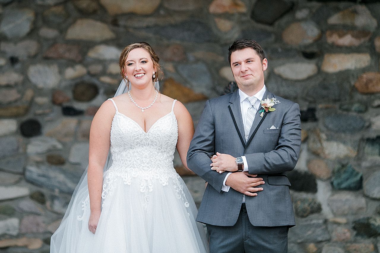 A bride and grooms smiling at their wedding ceremony in the Queens Courtyard at Castle Farms in Charlevoix, Michigan