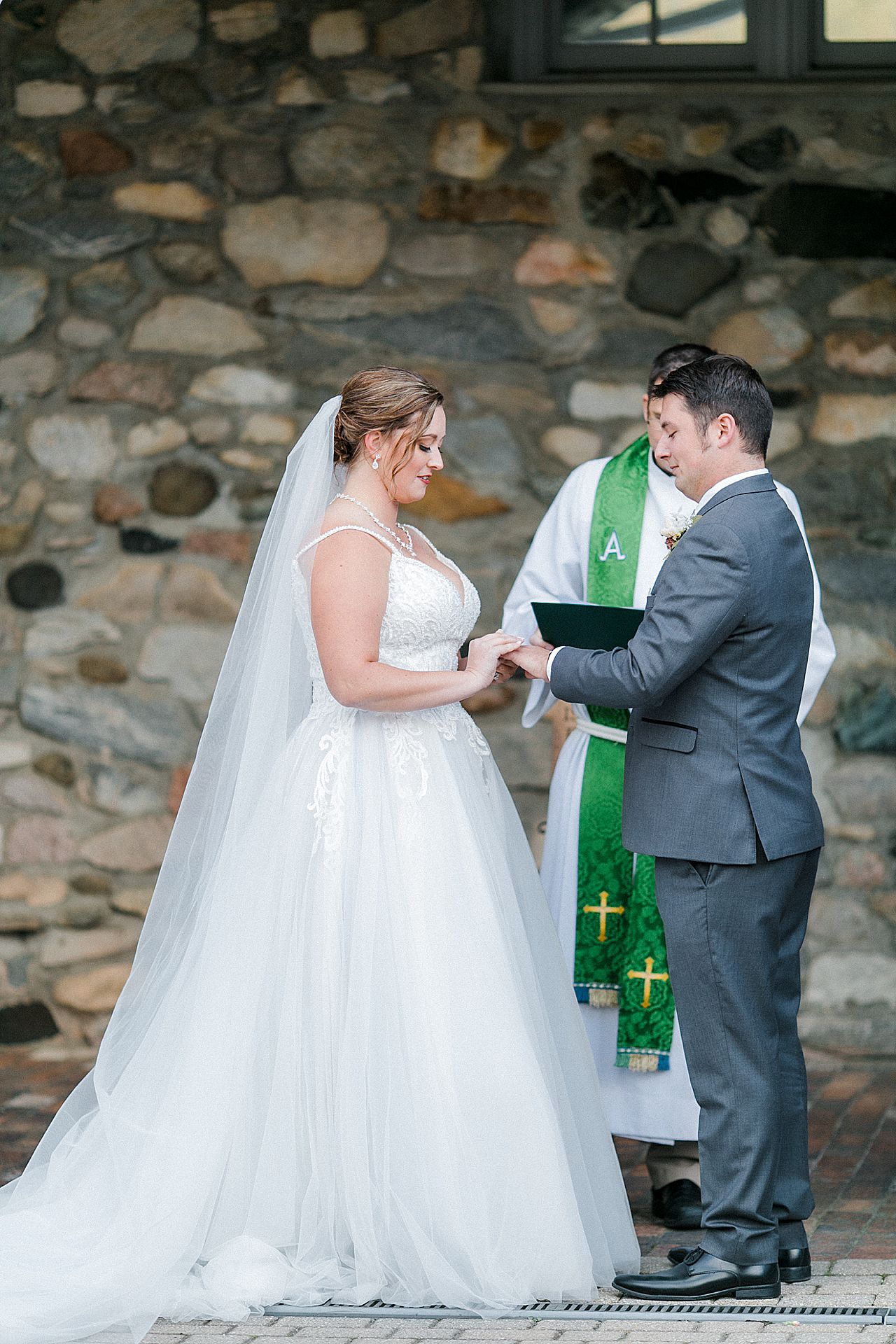 A bride and grooms exchanging wedding rings during their ceremony at Castle Farms in Charlevoix, Michigan