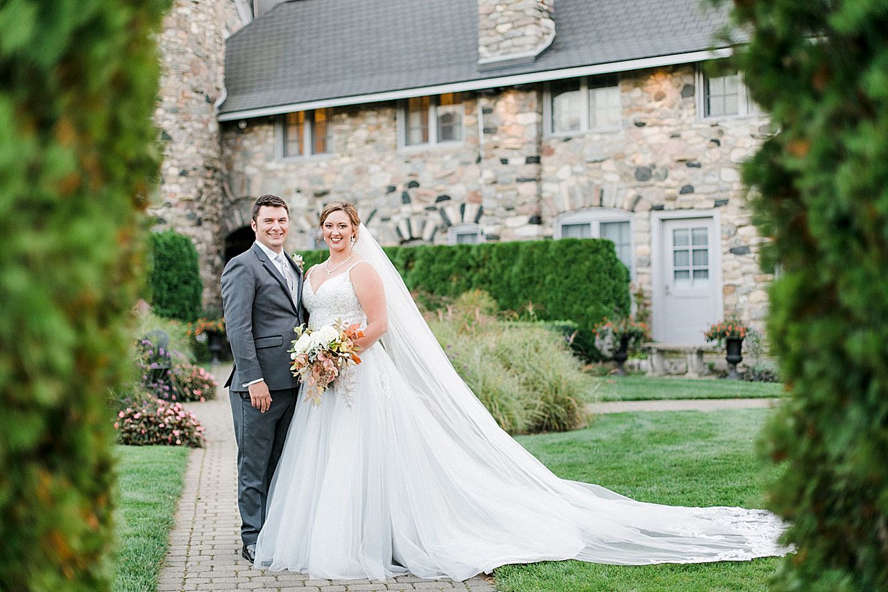 Bride and groom smiling in the butterfly garden at Castle Farms in Charlevoix, Michigan