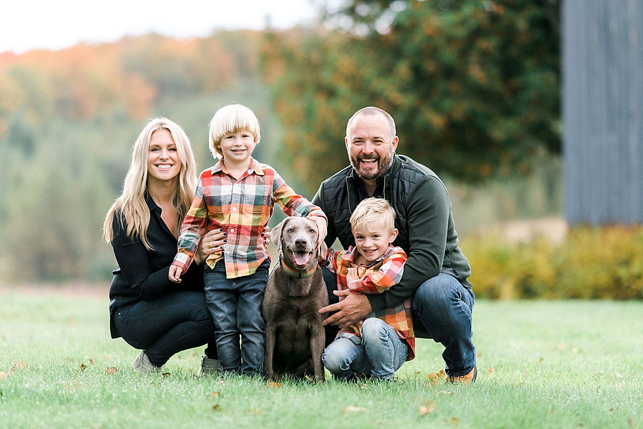Family portrait of a mother, father, their 2 sons, and the dog in the fall in Northern Michigan