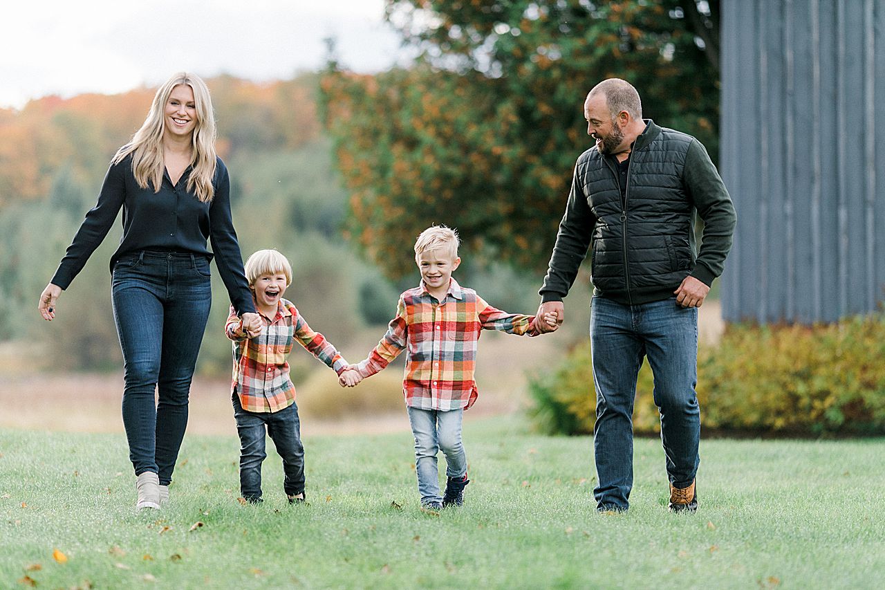 Family portrait of a family of 4 walking together in the fall in Northern Michigan