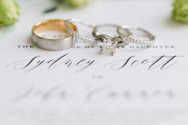 Wedding rings on a white wedding invitation at Aurora Cellars