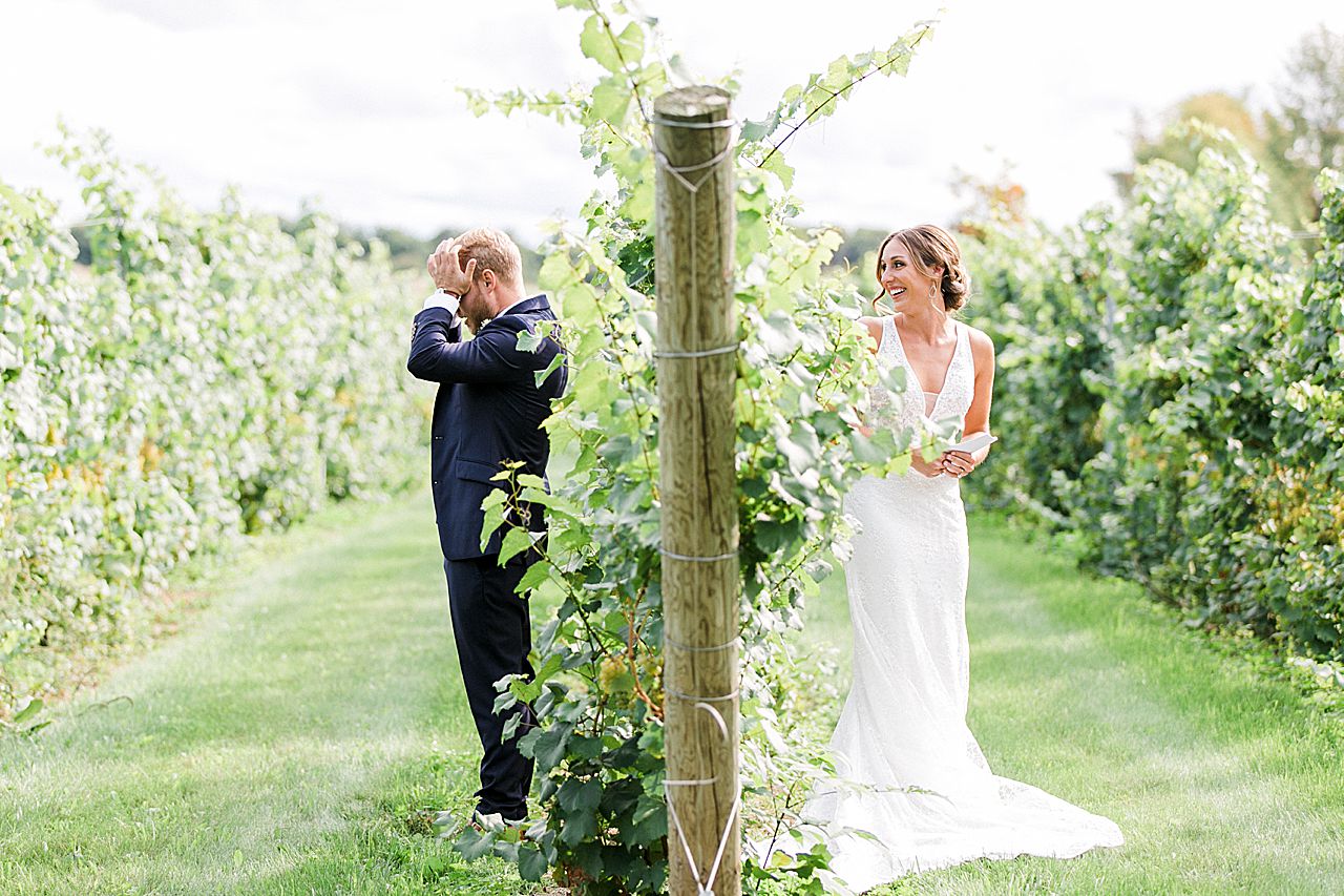 A bride and groom reading letters to each other in a vineyard at Aurora Cellars