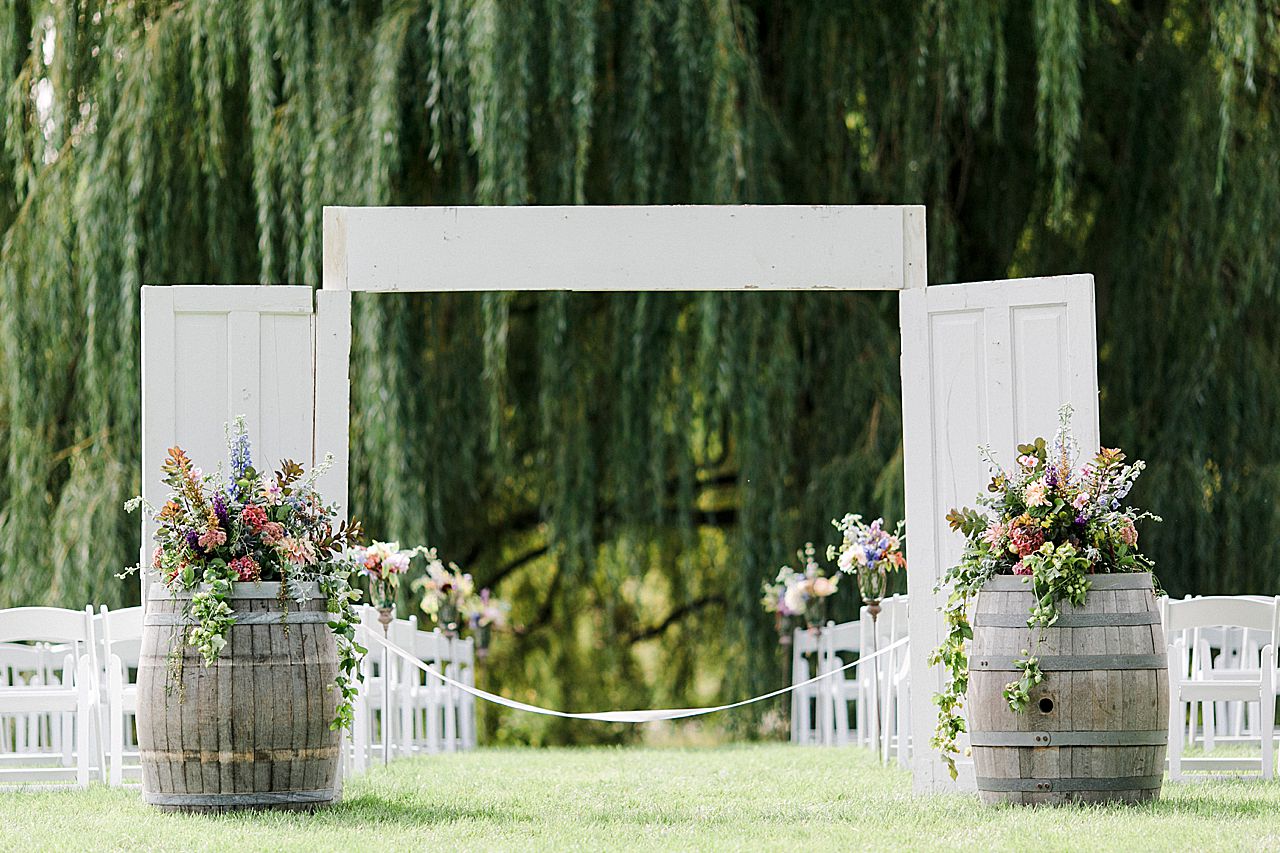 A wedding ceremony with doors and flowers setup at Aurora Cellars