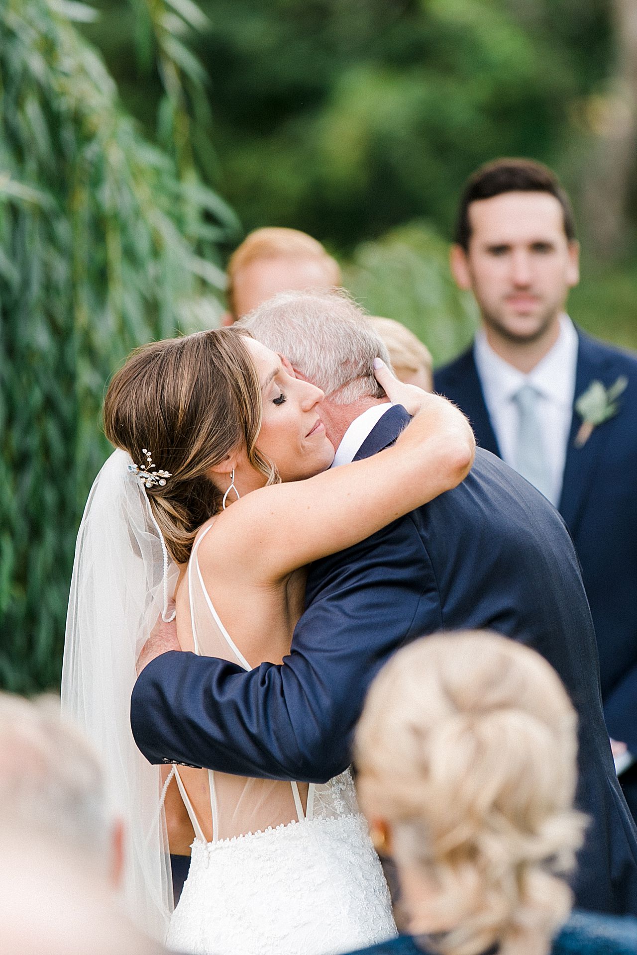 A bride hugging her father at her wedding ceremony at Aurora Cellars