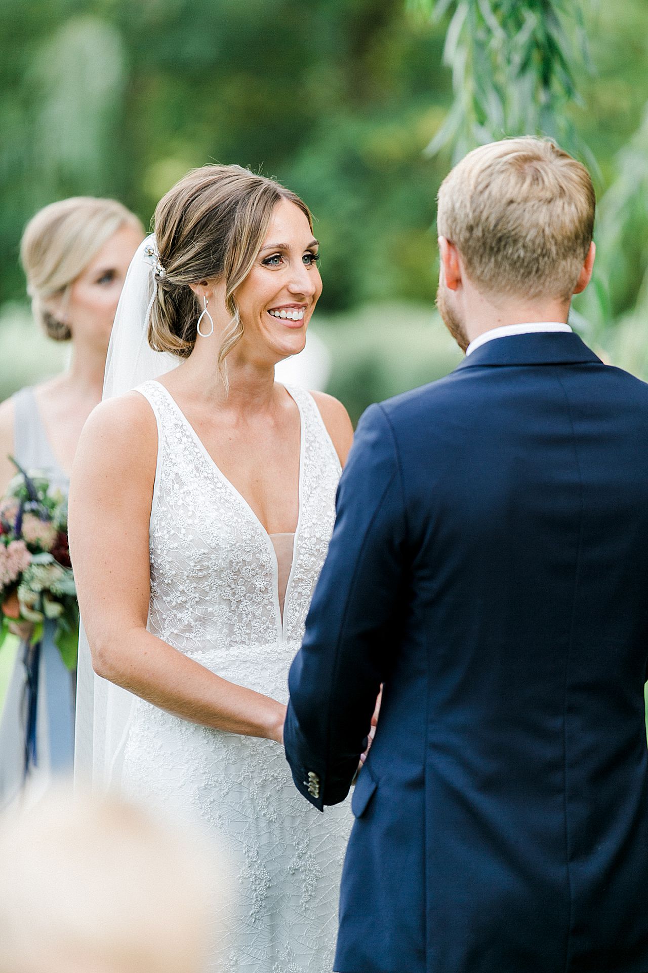 A bride smiling at her groom during their wedding ceremony in Northern Michigan